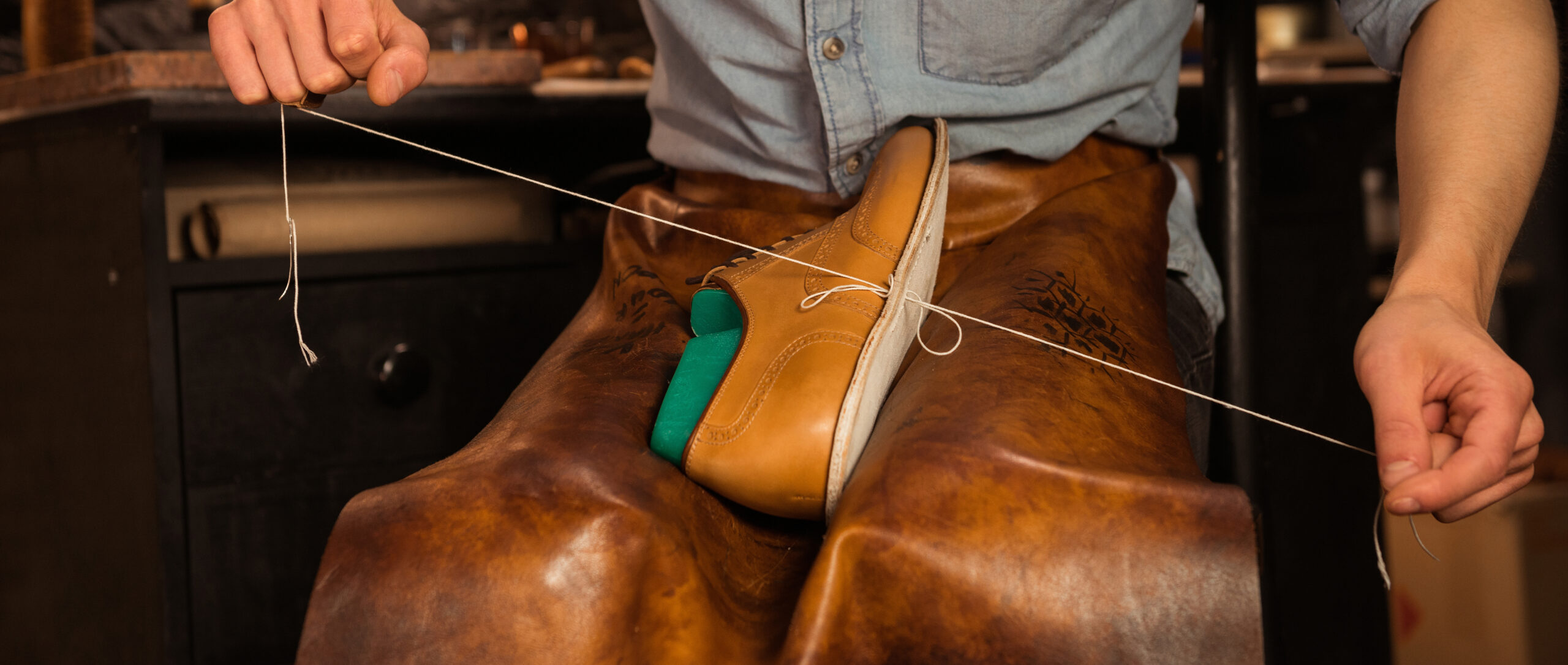 Shoemaker stitching a vegetable tanned leather shoe in a workshop
